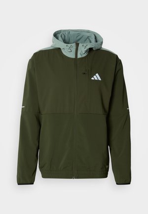 Sportjacke in Olivgrün mit hellgrünem Kapuzenfutter, durchgehendem Reißverschluss, elastischen Bündchen, zwei Fronttaschen und weißem Logo auf der Brust.