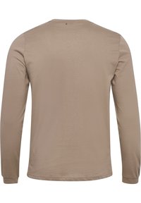 Beige pitkähihaainen paita pyöreällä pääntiellä, näkyy takaa, siinä on yksinkertaisia ompeleita ja pieni merkintä kauluksen lähellä.