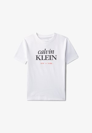 T-shirt bianca a maniche corte con "calvin KLEIN" in carattere nero e "NEW YORK" in piccolo testo rosso sotto sul petto.