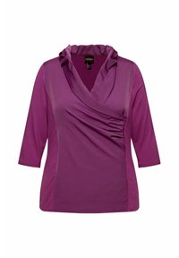 Lila Bluse f�ür Frauen mit Dreiviertelärmeln, rüschigem V-Ausschnitt und gerafften Details auf der Vorderseite.