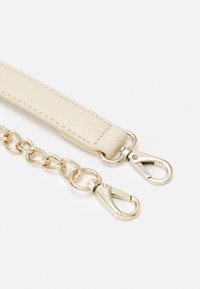 Bežna usnjena naramnica z teksturirano površino, ki vsebuje zlate kovinske verige in dva obračna jermenčka na vsakem koncu.