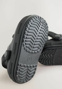 Zwarte sandalen van rubber, met een gegroefde zool met diepe profiel, verstelbare band en minimalistisch ontwerp. Maat gemarkeerd als 6.