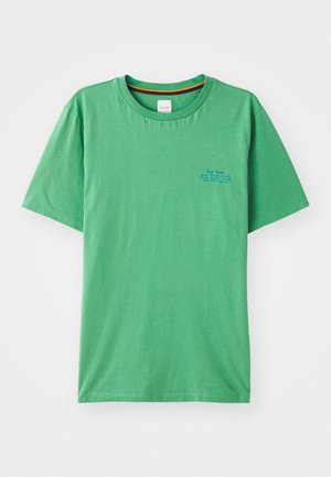 T-shirt en coton vert avec un col rond, des manches courtes et un petit texte bleu sur le côté gauche de la poitrine. Texture lisse.