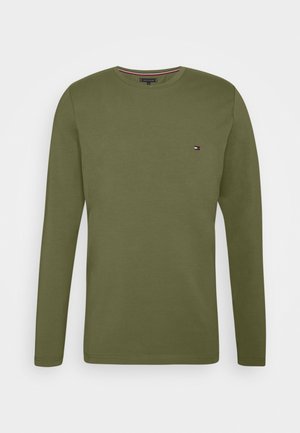 Olivenfarbiges Langarmshirt aus weicher Baumwolle mit Rundhalsausschnitt und kleinem Logo auf der Brust. Einfaches, schnörkelloses Design.