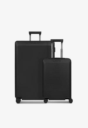 Juego de maletas rígidas negras con una textura suave, que incluye asas telescópicas y ruedas giratorias, compuesto por una maleta grande y una maleta pequeña.