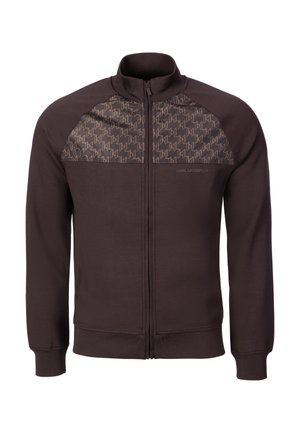 Mørkebrun jakke med lynlås, høj krave, mønstrede brystpaneler og ribbede manchetter og kant.