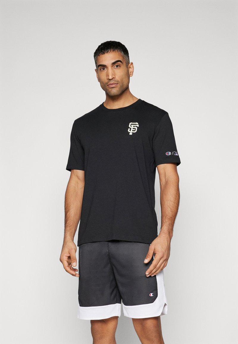 Svart bomull t-skjorte med en hvit og kremfarget "SF" logo på brystet, sammen med svarte mesh-shorts med hvit søm og logo.