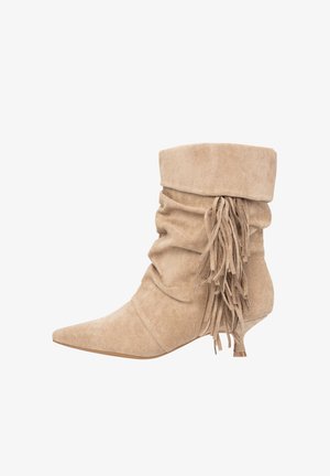 Beige suède enkellaarsjes met een slouches ontwerp, puntige neus en franjes aan de achterkant. Lage, taps toelopende hak voor subtiele verhoging.