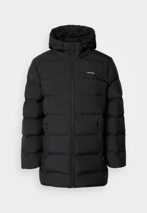 Chaqueta de plumas negra con cremallera frontal, capucha ajustable con cordón, patrón acolchado y logo de la marca en el lado izquierdo del pecho. Cuenta con bolsillos laterales.