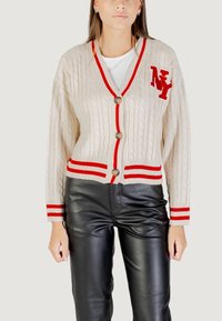 Cardigan a maglia beige con bordi rossi a contrasto, caratterizzato da una trama a treccia, tre bottoni e un logo ricamato 'NY' sul petto.