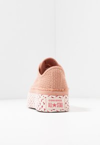Różowy pleciony sneaker na wysokiej platformie z plecioną teksturą, brandingiem Converse na pięcie oraz zaokrąglonym, minimalistycznym designem.