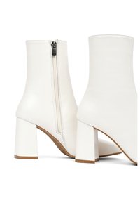 Bottes blanches à chevilles en cuir avec une texture lisse, dotées d'une fermeture éclair sur le côté et d'un talon carré.