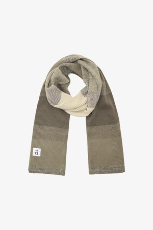 Écharpe tricotée dans des tons terreux d'olive et de crème, présentant une texture côtelée et une étiquette portant "M 73". Design enroulé.