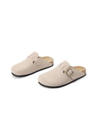 Zoccoli in suede beige con punta arrotondata, cinturino regolabile con fibbia e interno testurizzato. Suola in gomma nera per durabilità e comfort.