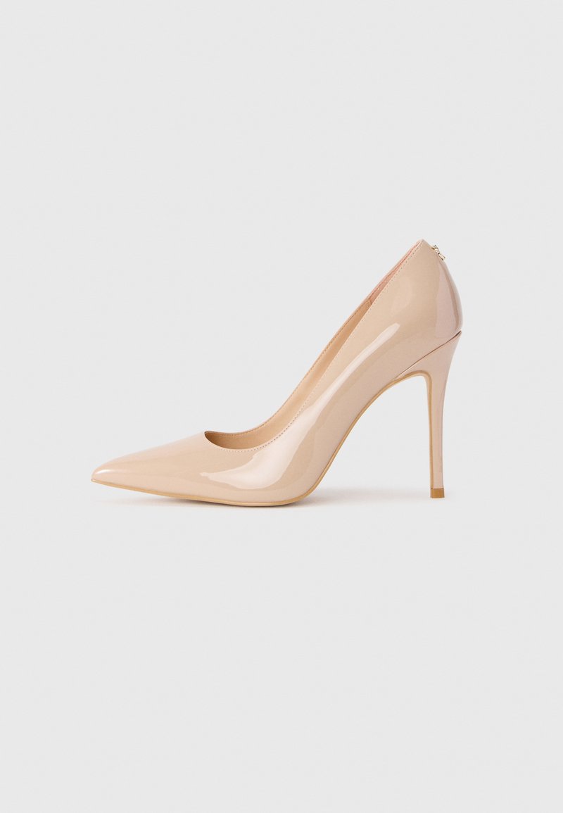 Pointed-toe high heel shoe in glossy nude patent leather; features a tapered silhouette and a slim, tall stiletto heel.