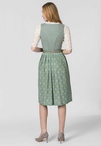 Green dress with pleated skirt, solid bodice, and lace sleeves. Features a fitted back and silk ribbon belt, with a subtle floral pattern.