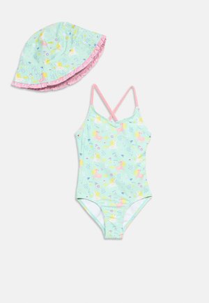 Mintgroene kinderbadpak met bijpassende zonnehoed met roze bandjes en eenhoornprint, hoed afgezet met roze ruches.