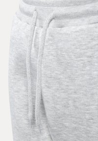 Lys grå sweatpants med et struktureret stof, ribbet talje og vævede snore. Designet er enkelt med en glat finish.