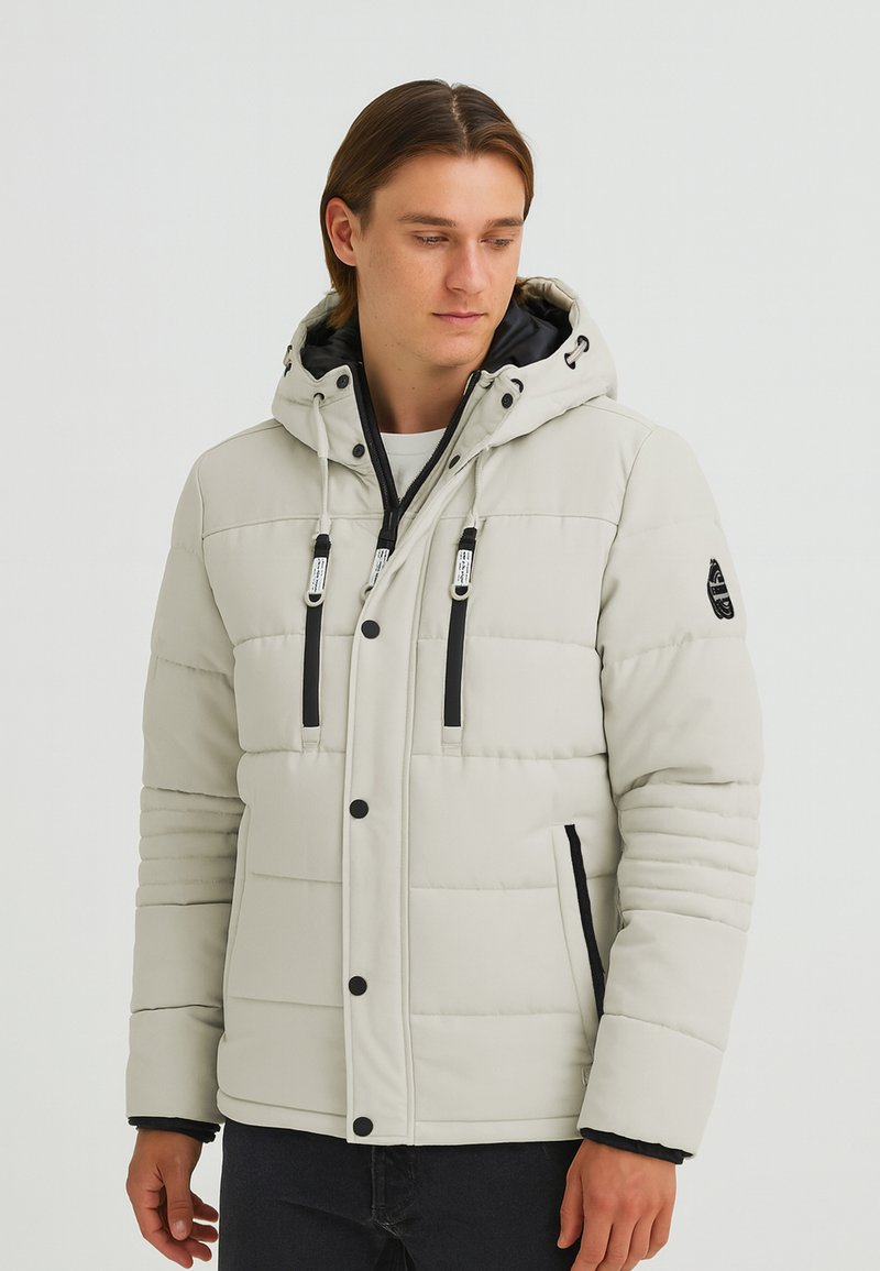 Quilted white puffer jacket with a hood, featuring black accents, adjustable drawstrings, and zippered side pockets. Soft texture.