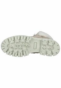 Semelle en caoutchouc texturé de couleur claire avec des crampons profonds et des motifs en forme d'étoile ; conception robuste pour une meilleure adhérence et traction.