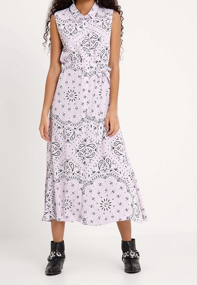 Różowa sukienka bez rękawów z czarnymi wzorami paisley, z kołnierzykiem, w talii z paskiem, zwiewny dół, zestawiona z czarnymi botkami za kostkę.