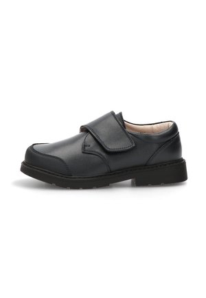 Zapato escolar negro de cuero con correa ajustable de velcro, puntera reforzada, tacón bajo y cuello acolchado.