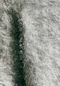 Puchaty, jasnoszary materiał o teksturowanej powierzchni, z błyszczącymi srebrnymi włóknami wplecionymi w całość, tworzącymi błyszczący efekt.