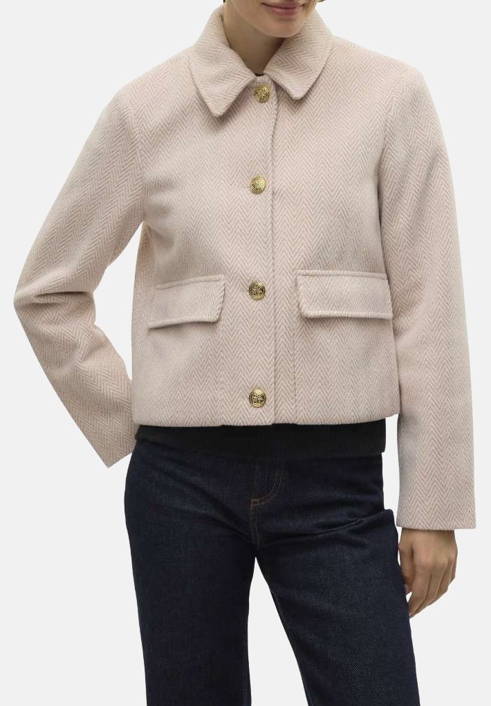 Veste herringbone rose courte avec col, ornée de boutons dorés, de deux poches avant et d'une bande inférieure noire ajustée.