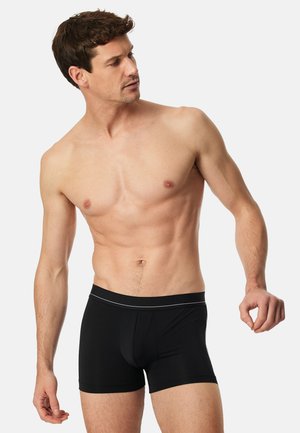 Sorte boxer briefs med en bred elastisk linning, der har en tynd sølvstribe, lavet af et glat, strækbart materiale.
