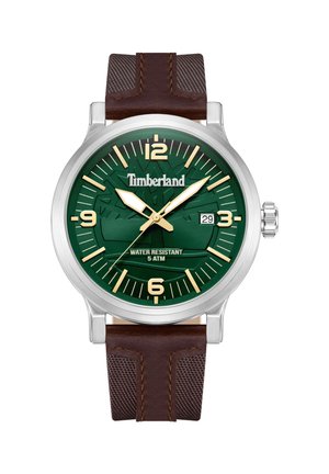 Timberland pulksteņi ar zaļu teksturētu ciparnīcu, zeltainiem rādītājiem un sudraba nerūsējošā tērauda korpusu. Brūna ādas siksna ar acu akcentiem. Ūdensizturīgs.