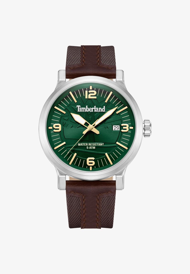 Reloj Timberland con esfera verde texturizada, marcadores dorados y caja de acero inoxidable plateada. Correa de cuero marrón con acentos de malla. Resistente al agua.