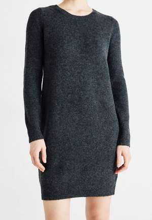 Robe en maille gris foncé à manches longues avec col rond, poignets et ourlet côtelés, portée par une personne debout sur un fond clair uni.