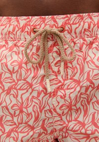 Shorts de bain en tissu léger avec un motif floral rose. Avec une taille élastique, un cordon de serrage, et des détails de couture contrastants.