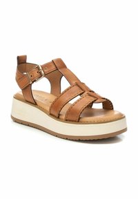 Sandalias de plataforma de cuero marrón con diseño recortado, hebilla ajustable y acentos de costura. Suela intermedia blanca y suela de goma texturizada.