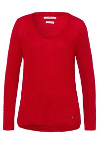Pull en tricot rouge avec un col en V, des manches longues, un ourlet légèrement asymétrique et un petit logo en bas à gauche.