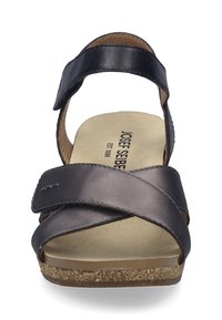 Schwarze Leder-Sandale mit überkreuzten Riemen, strukturiertem Fußbett und Korksohle. Verstellbarer Riemen für einen sicheren Halt; sauberes, funktionales Design.