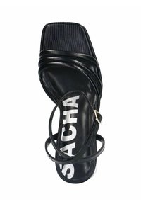 Zwarte leren sandaal met een vierkante neus, getextureerde banden en een logo op de binnenzool. Voorzien van een dunne enkelband en een platte zool.
