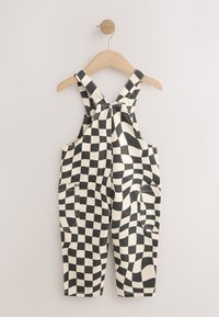 Salopette a quadretti bianco e nero, con bretelle regolabili, due tasche frontali e vestibilità ampia. Realizzata in tessuto di cotone dalla texture morbida.