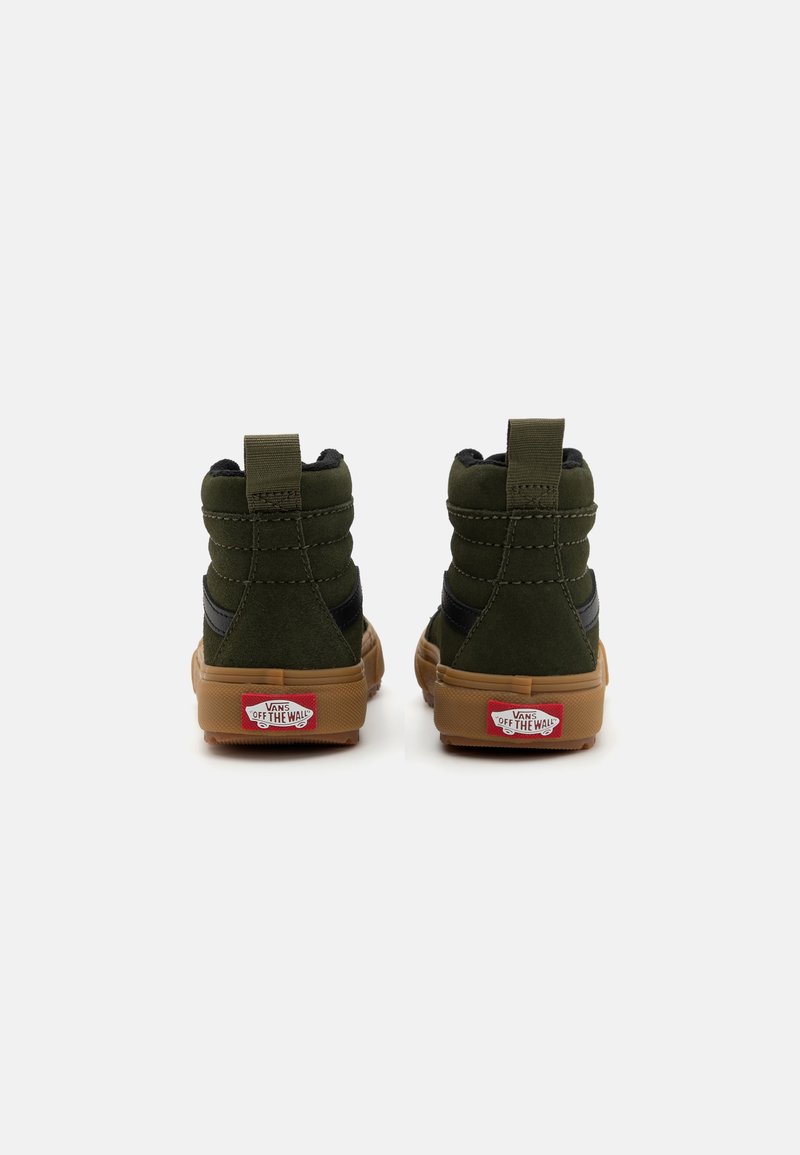 Zapatillas altas de ante verde oscuro con acentos en negro y suelas de goma. Cuentan con un tirador en la parte trasera y detalles del logo en el talón.