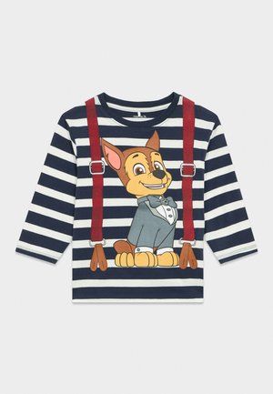 Tengerészkék és fehér csíkos hosszú ujjú ing, elöl rajzfilm kutyával, amely szmokingot visel és nyomtatott piros kantárokkal.