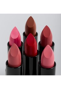 Six rouges à lèvres dans des tubes cylindriques noirs, présentant différentes teintes : un rose scintillant, un rouge profond, un nude et un rose doux, chacun avec un embout pointu.