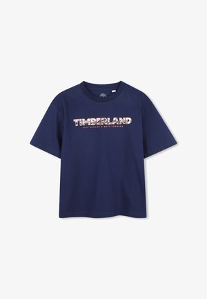 Marineblauw T-shirt met korte mouwen, bedrukt met de tekst "TIMBERLAND" en de slogan "STEP OUTSIDE & MOVE FORWARD" in wit en oranje op de voorkant.