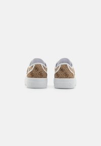 Bruna mönstrade sneakers med vita sulor och detaljer, som har en upprepad logodesign och en slät yta på baksidan.
