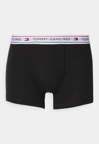 Boxers negros de tela suave con una cinturilla blanca que presenta "TOMMY JEANS 1985" en texto rojo y azul. Textura lisa y diseño ajustado.