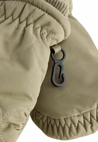 Moufle isolée beige avec texture matelassée, poignets élastiques et un clip en métal noir. La surface est lisse avec des coutures contrastées.