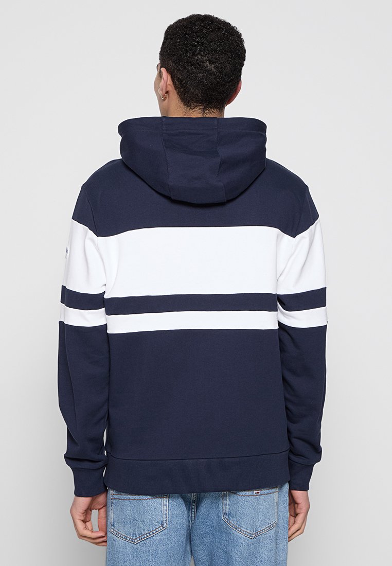 Felpa con cappuccio blu navy con strisce orizzontali bianche, in cotone, con polsini a coste. Vista posteriore senza ulteriori dettagli.