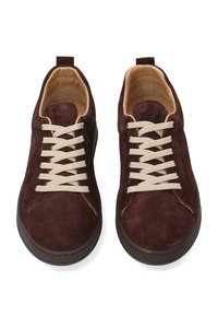 Bruine suède sneakers met beige veters, afgeronde neus, contrasterend stiksel en zwarte rubberen zool. Lusje aan de hiel voor gemakkelijk aan- en uittrekken.