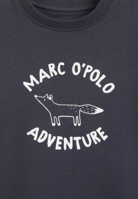 Felpa scura navy con una grafica bianca di una volpe e il testo "MARC O'POLO ADVENTURE" in un font rotondo. Materiale misto cotone, texture morbida.