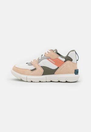 Lav sneaker med hvidt mesh, beige ruskindsoverlejringer, olivengrønne detaljer, koralstribe med "SOREL"-mærkning og hvid gummisål.