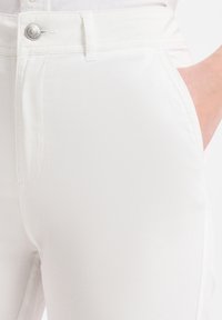 Weiße Baumwollmischhose mit klassischem Knopfverschluss, Seitentaschen und glatter Textur mit minimalen Nähdetails.